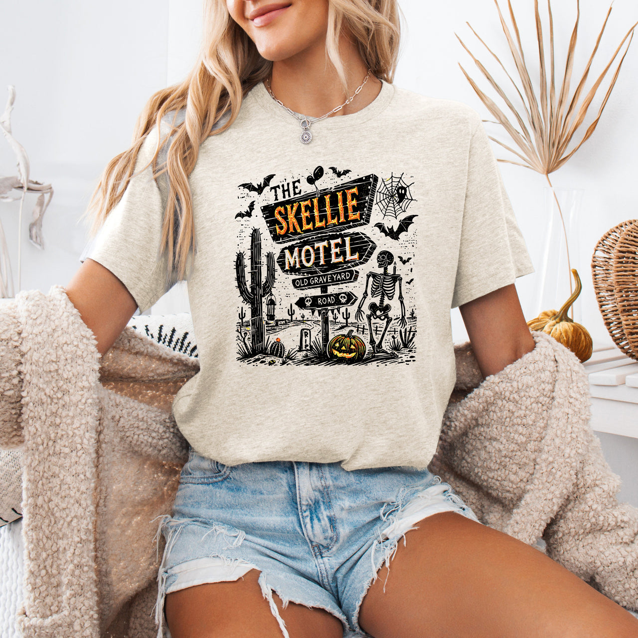 The Skellie Motel Graphic Tee Featuring Skeleton Halloween Artwork Perfect For Spooky Season